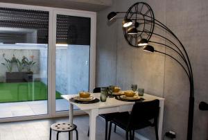 ein Esszimmer mit einem weißen Tisch und einer Lampe in der Unterkunft Casa das Falcoeiras - Estúdio com terraço privado in Aveiro + 10 Fotos