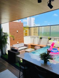 patio con mesa y sillas en el balcón en Apartamento Duplex Vista Mar em Natal, en Natal