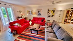 een woonkamer met twee rode banken en een tapijt bij Villa Linda in Margon