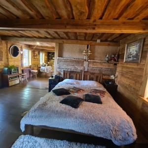 Un dormitorio con una cama grande en una habitación con techos de madera. en Atomi, en Aucugals
