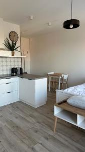a kitchen with white cabinets and a table in a room at Apartamenty Mickiewicza40 in Śrem