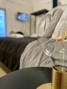 a wine glass sitting on a table next to a bed at Suite Caronda in Catania