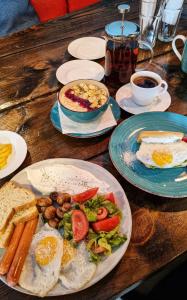 a wooden table with plates of breakfast foods and coffee at New Gudauri Lofts by Gudauri Travel in Gudauri