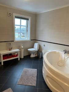 a bathroom with a tub and a toilet and a sink at Familievennlig leiligheten leies ut på Sørlandet. in Vennesla