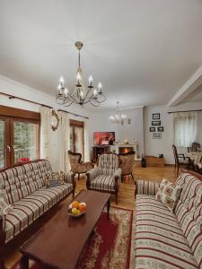 una gran sala de estar con sofás y una mesa. en Vila Marina, en Jahorina