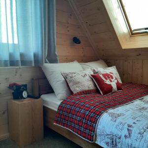 um quarto com uma cama num chalé de madeira em Szałas Kosówka em Witów