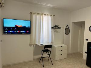 a room with a desk and a television on a wall at Hotel Iacone in Chieti