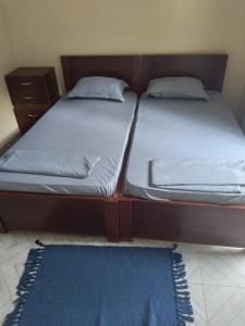 2 Einzelbetten in einem Zimmer mit blauem Teppich in der Unterkunft Pam de Terra in Calheta