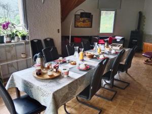 a long table with chairs and food on it at Chambres d'hotes La combette in Le Bleymard