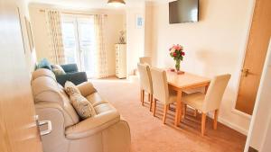 a living room with a couch and a table at Sandy Bay Apartment, St Ives Bay, Hayle in Hayle