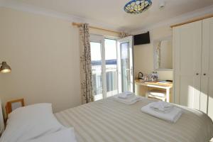 a bedroom with a bed with two towels on it at Sandy Bay Apartment, St Ives Bay, Hayle in Hayle