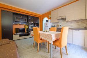 cocina y comedor con mesa y sillas en Happy Home, en Taormina