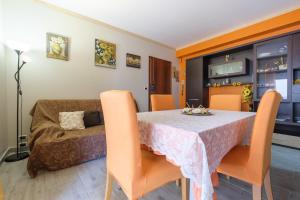 comedor con mesa, sillas y sofá en Happy Home, en Taormina