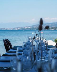 un tavolo con occhiali e vista sull'oceano di Hôtel de la Plage a Excénevex