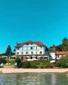 un hotel en la orilla de una playa cerca del agua en Hôtel de la Plage, en Excenevex