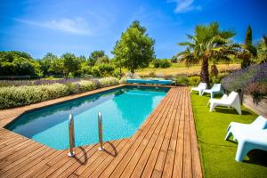 una piscina con una terraza de madera y sillas en un patio en Gîte Vent Autan - Holiday Home Vent Autan, en Limoux