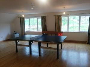 a ping pong table in a living room with windows at Bunloyne in Sallachy