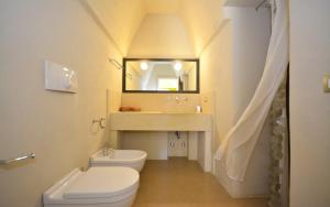 y baño con aseo, lavabo y espejo. en Masseria Bernardini Art Resort, en Nardò