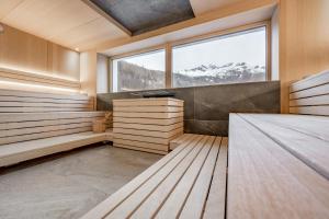 a sauna with a large window and wooden floors at Camping Sölden Apartments in Sölden
