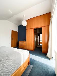 a bedroom with a bed and wooden cabinets at Fado Apartments Lendava in Lendava