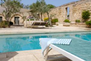 una piscina con un banco junto a una piscina en Masseria Bernardini Art Resort, en Nardò
