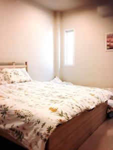 um quarto com uma cama com um edredão floral em Chiangmai Family Suite-Blue eye bunny em Chiang Mai