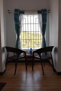 a table and two chairs in front of a window at DIAMOND HILL VIEW in Ketti