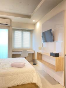 a bedroom with a bed and a flat screen tv at Apartemen Grand Sentraland by My room in Karawang