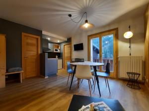 een keuken en een woonkamer met een tafel en stoelen bij Appartement Les 3 cols Morzine, 2 pièces, 2 personnes in Morzine