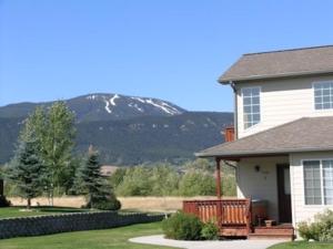 uma casa com um alpendre com uma montanha ao fundo em Beartooth_Montana_Getaway em Red Lodge