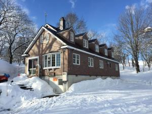 una casa está cubierta de nieve en Guest House Bunk, en Myoko