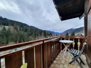 einen Balkon mit einem Tisch, Stühlen und Bergen in der Unterkunft Appartement Les 3 cols Morzine, 2 pièces, 2 personnes in Morzine