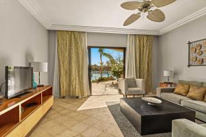 sala de estar con sofá y TV en Beautiful apartment with pool view, en Punta Cana