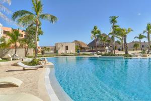 una piscina con palmeras en un complejo en Beautiful apartment with pool view, en Punta Cana