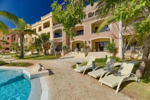 un complejo con piscina, sillas y un edificio en Beautiful apartment with pool view, en Punta Cana