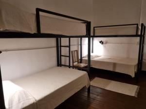 a room with two bunk beds and a chair at Posada Las Chacras in Ciudad Lujan de Cuyo