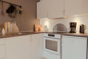 a kitchen with white cabinets and a sink at Unique Boathouse - Central - Kajak - Fitness in Strendur