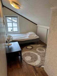 Habitación pequeña con cama y alfombra. en Familievennlig leiligheten leies ut på Sørlandet. en Vennesla