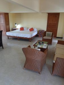 a bedroom with a bed and a couch and a table at DINO 2 in Trou aux Biches