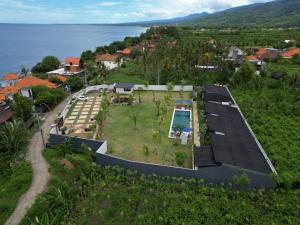 - une vue aérienne sur une maison avec une piscine dans l'établissement IBI bali, à Banjar