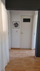 a hallway with a white door and a wooden floor at Departamento en increíble ubicación in Mendoza