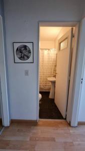 a hallway with a bathroom with a toilet and a picture on the wall at Departamento en increíble ubicación in Mendoza