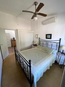 1 dormitorio con cama negra y ventilador de techo en Martin Fierro, en La Floresta