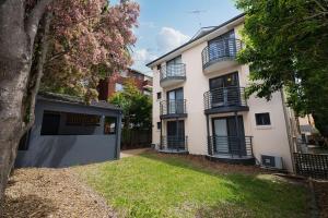 a white building with balconies and a yard at Hornsby Furnished Apartments in Hornsby