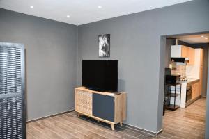 un soggiorno con TV a schermo piatto a parete di Logement in wood (400 mètres de Pairi Daiza) a Bolignies