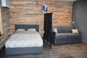 una camera con letto e divano di Logement in wood (400 mètres de Pairi Daiza) a Bolignies