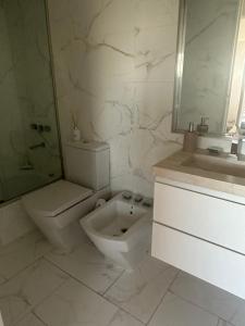 a white bathroom with a toilet and a sink at Departamento luminoso y amueblado en caballito in Buenos Aires