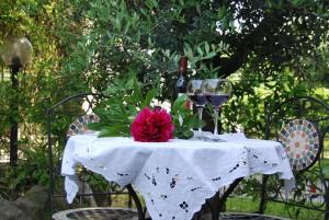 a table with wine glasses and a pink flower on it at Il Gabbiano in Ameglia