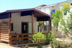 a house with a porch and a wooden fence at Camping Serenella in Rodi Garganico