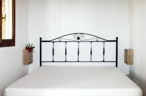 a bed in a white room with a black frame at Camping Serenella in Rodi Garganico